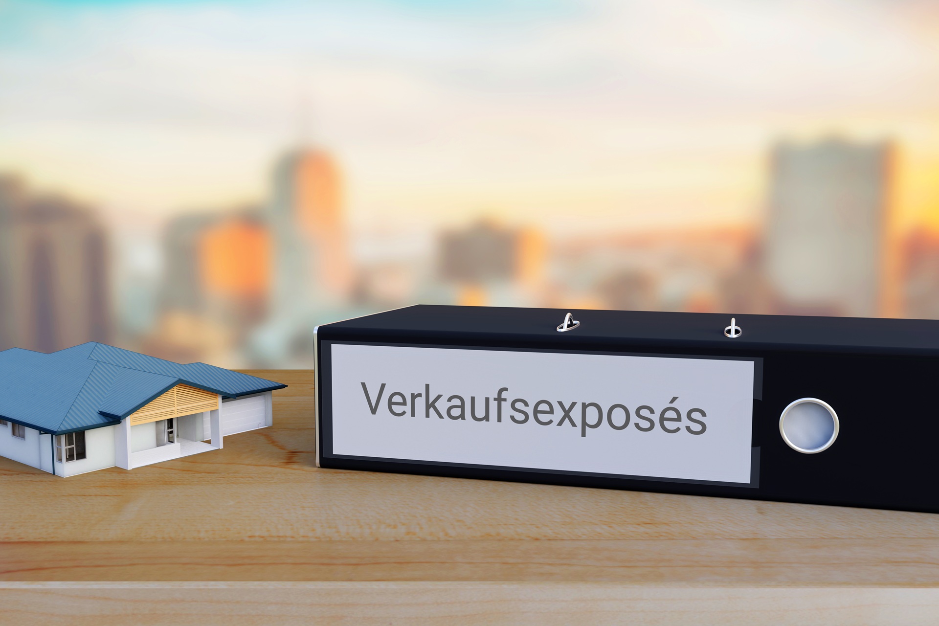 Exposé-Ordner neben kleinem Hausmodell | Immobilienbewertung Stuttgart
